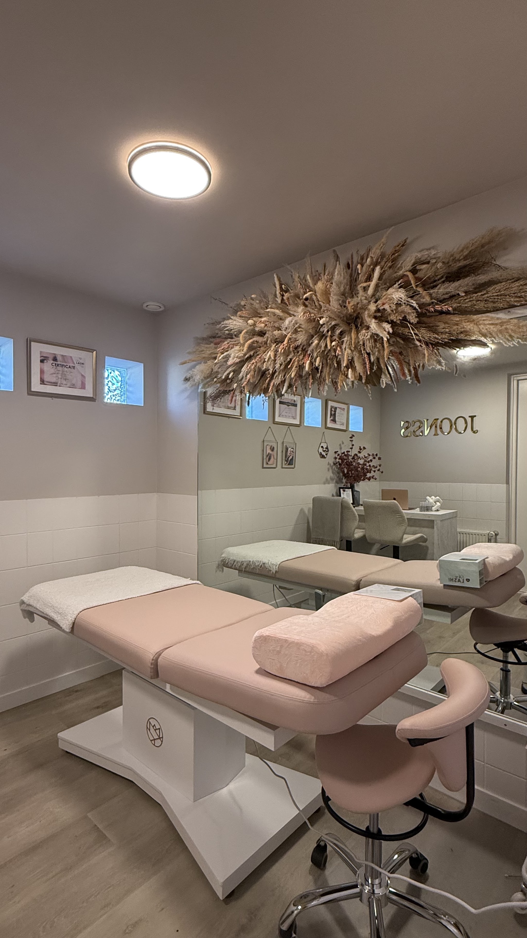 De lashroom van Wimpers by Joonss in Veldhoven: blush behandelbed, spiegelwand en een droogbloemenstuk aan het plafond